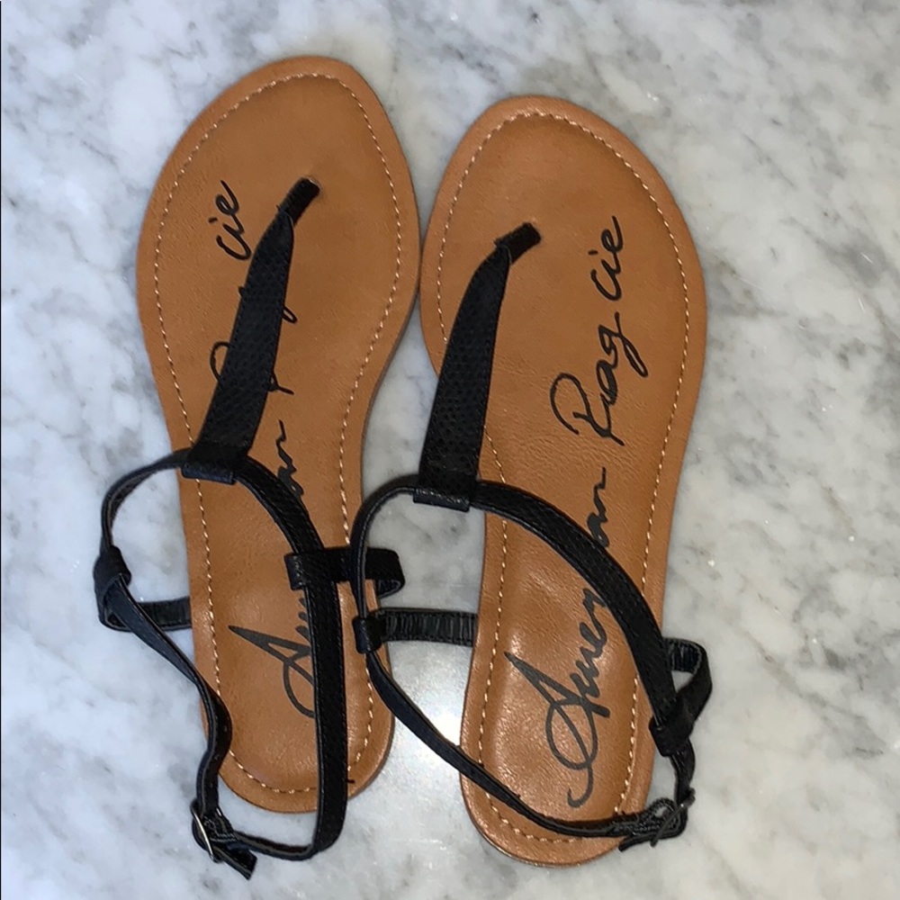 Black strapped sandals, with a brown sole.